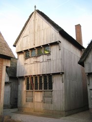 <p>Reconstructie van een 14e eeuws houten huis met een verdieping met daarnaast en tegenover verdiepingloze houten huizen (Archeon). </p>
